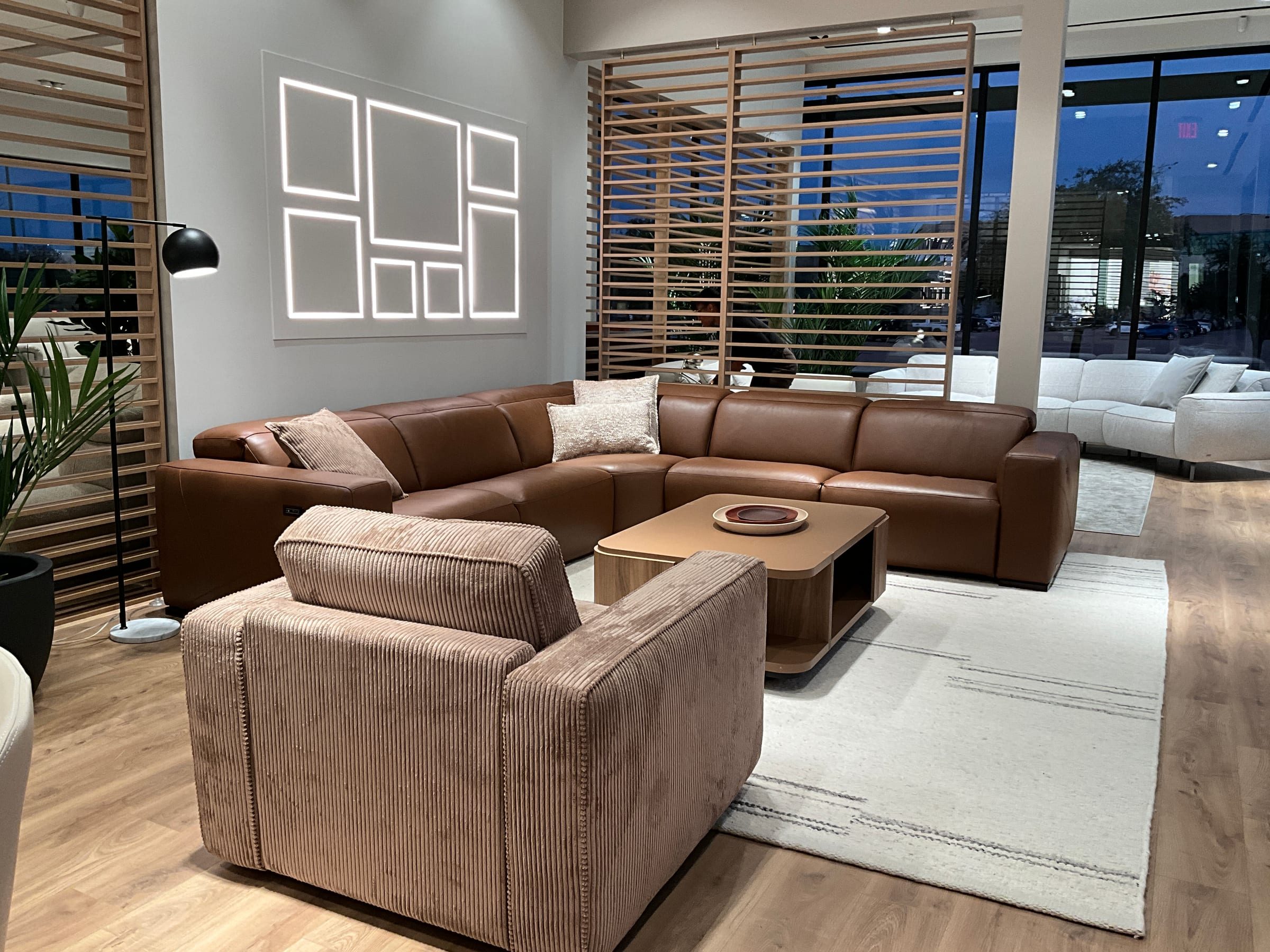Entry vignette of a Natuzzi Editions store, a sectional group staged against the main sightline.