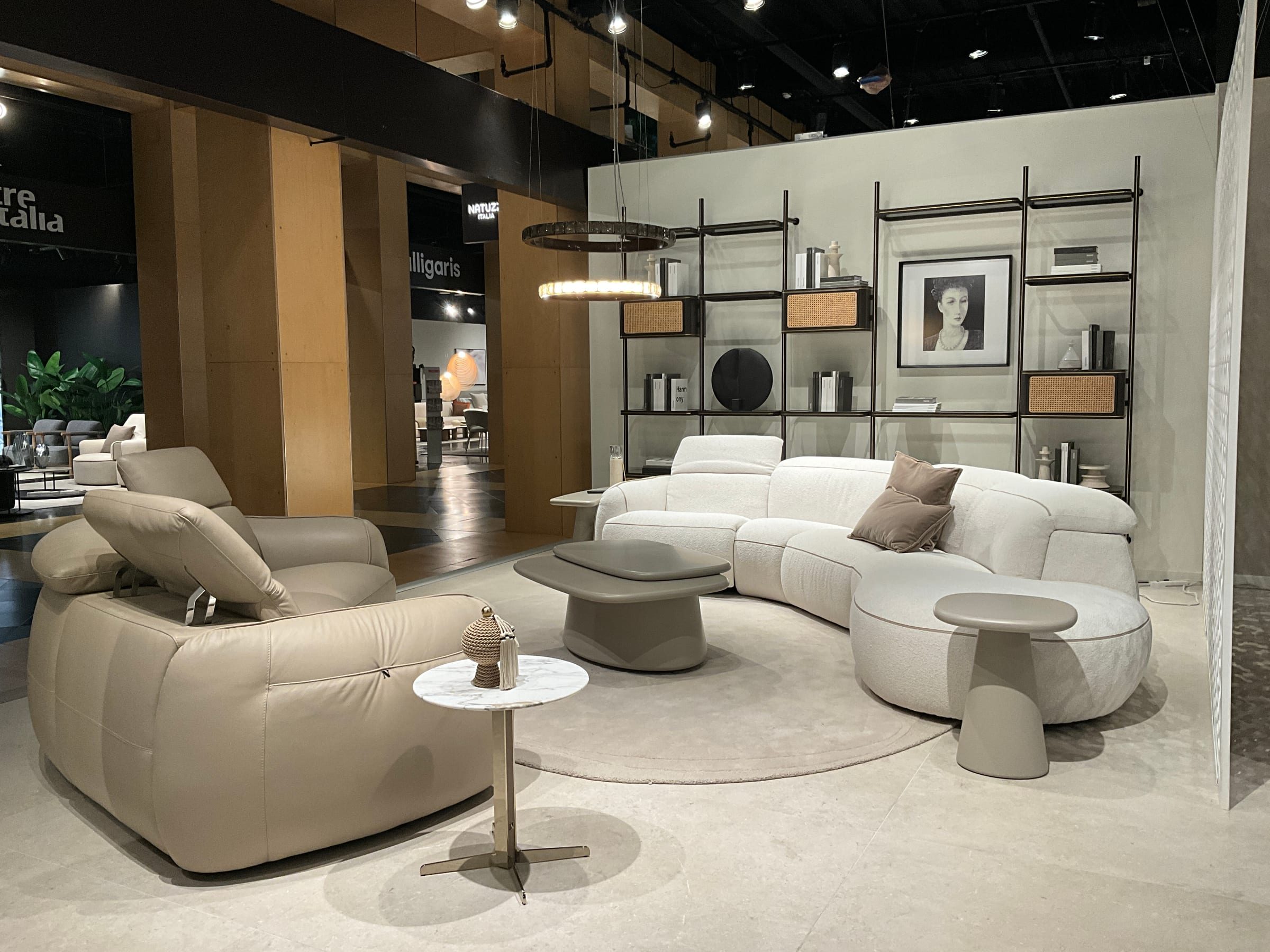 Upholstery grouping staged with occasional tables and accessories for buyer presentation.